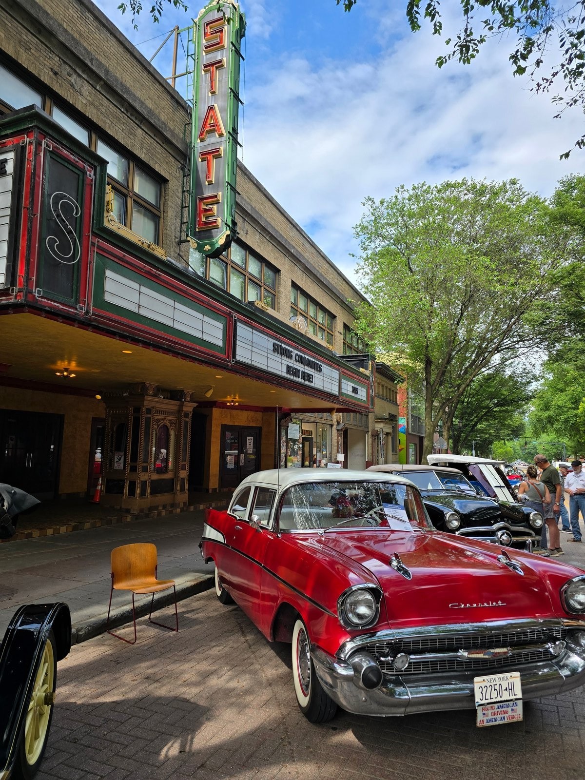 Red 1957 Chevrolet parked in front of the State Theatre marquee on West State Street
